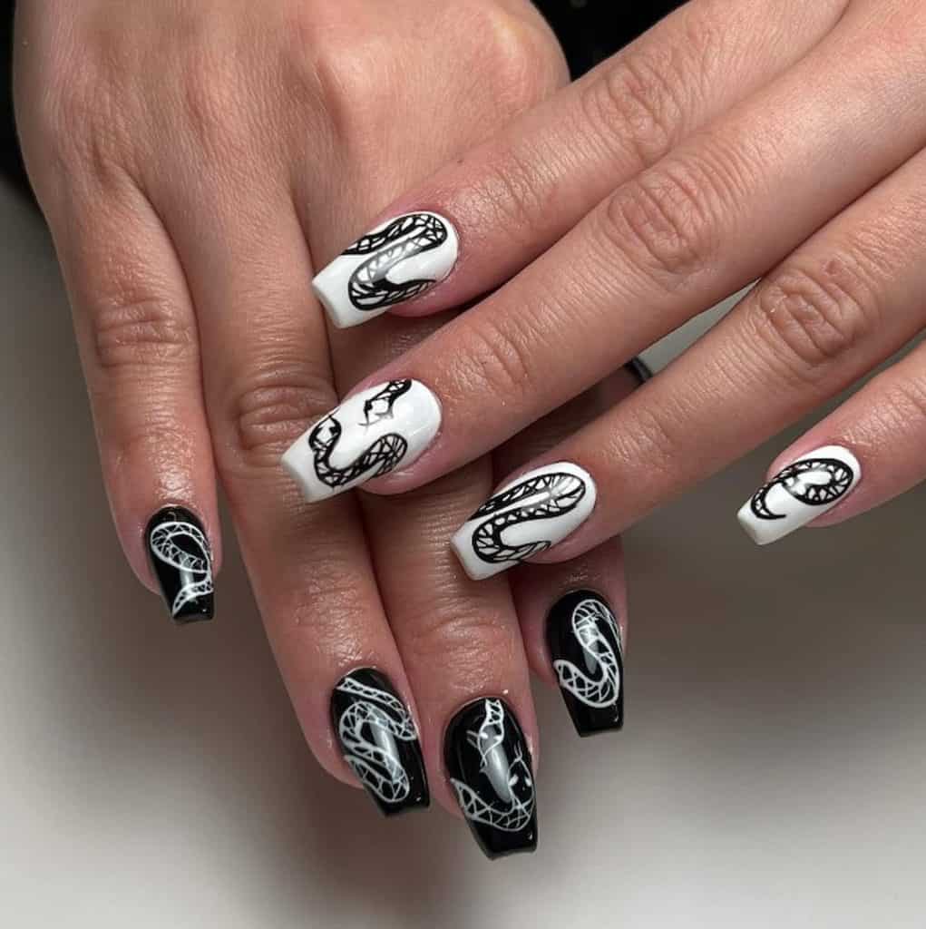 A closeup of a woman's hands with combination of black and white nail polish that has serpent nail designs 