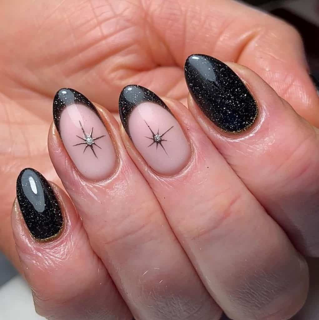A closeup of a woman's house with a pale pink and black nail polish that has black tips, star and glitter