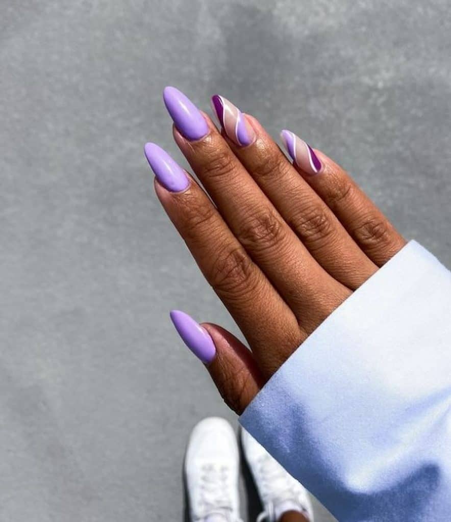 A woman's hand with light and dark purple nail polish 
