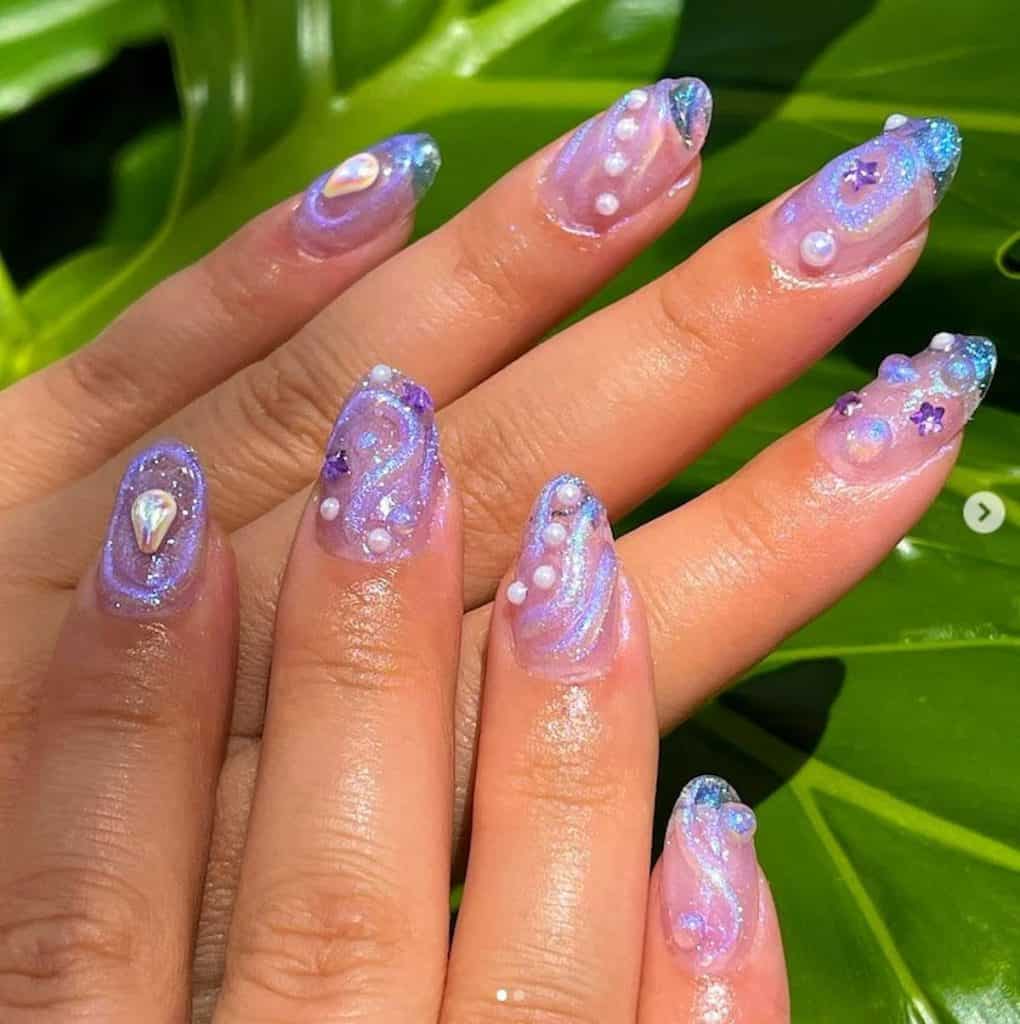 A woman's hands with lavender colored nails, glitter and pearl designs