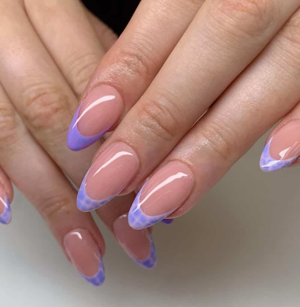 A woman's hands with nude nail polish and lavender tips