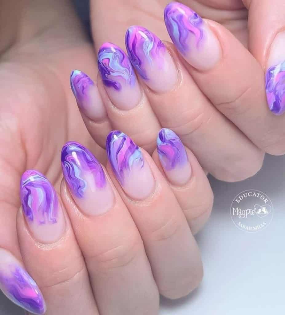 A woman's hands having an artsy lavender nails with a combination of pastel blue and pink nail polish