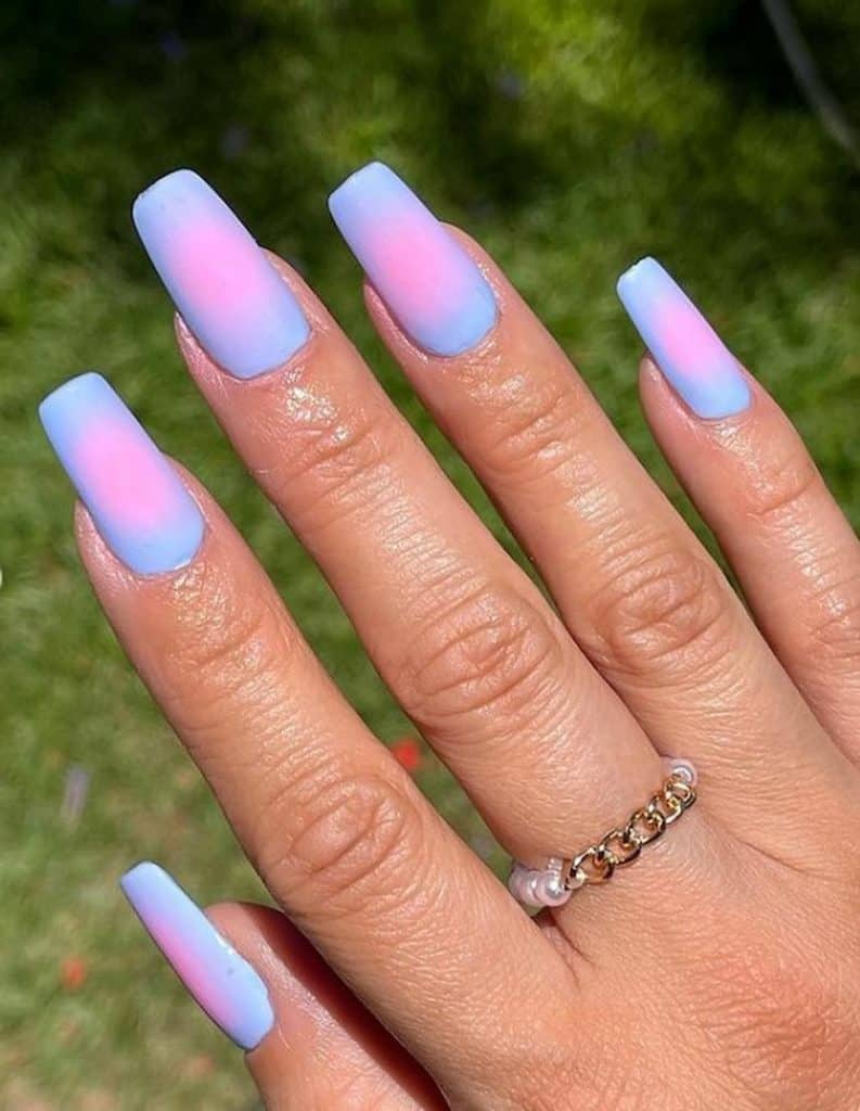 A woman's hand having a lavender and pink matte nails 