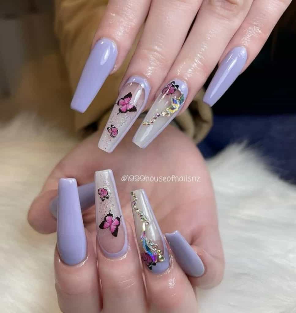 A woman's hands with lavender nails, butterfly and gold jewel designs