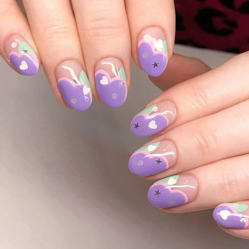 A woman's hands with a combination of lavender and pastel nail colors. It has small hearts and stars designs