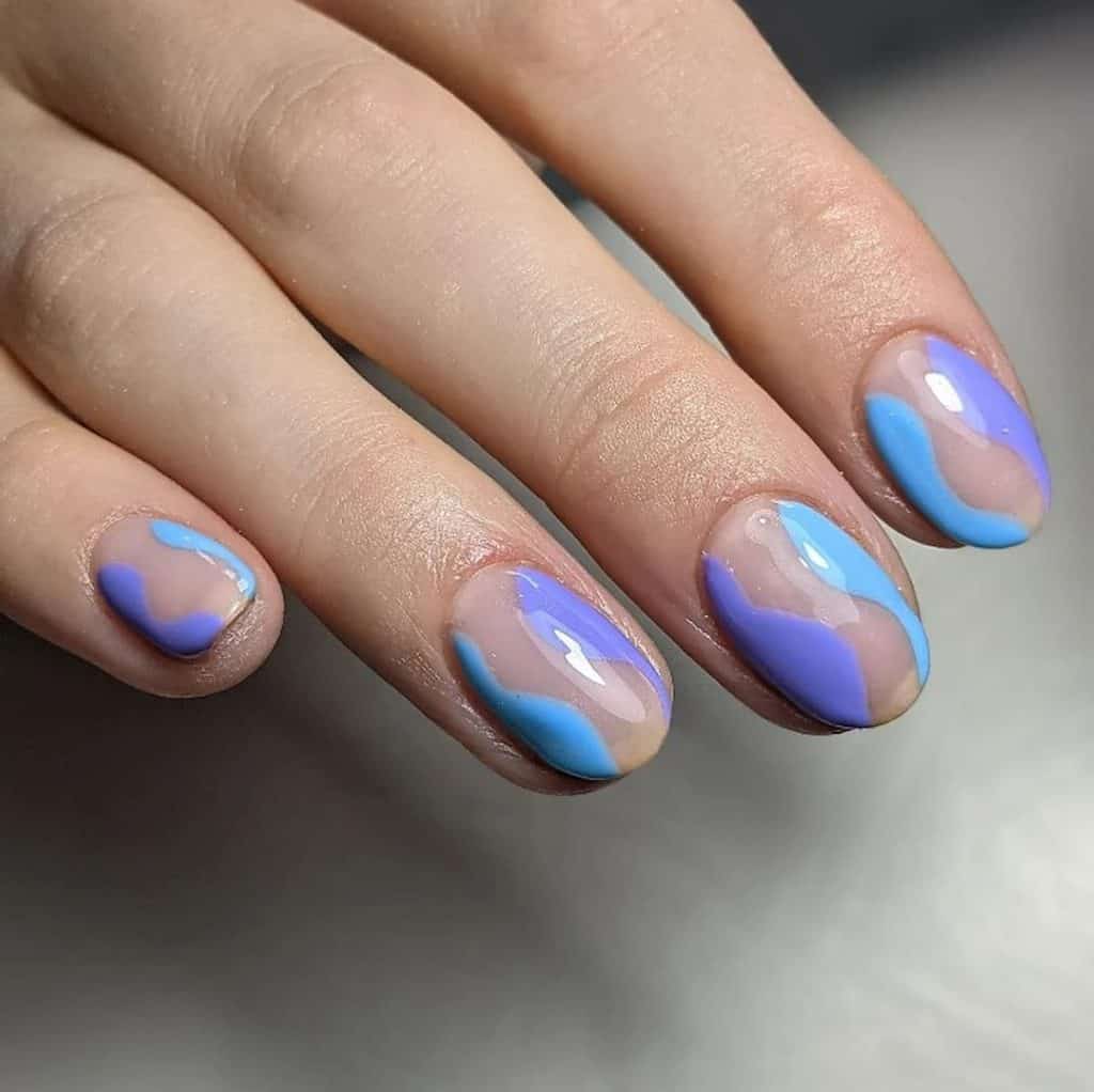 A woman's hand with a combination of blue and lavender nail designs 
