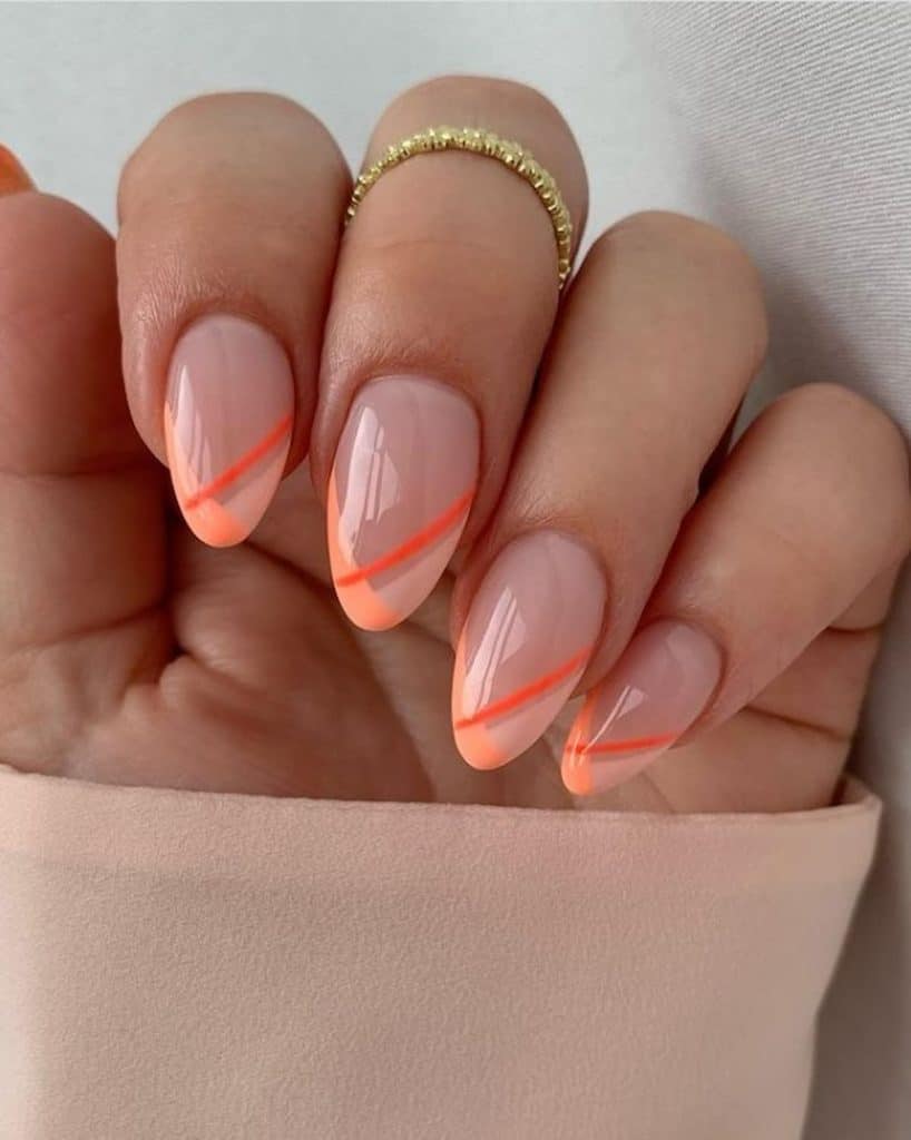 A closeup of a woman's hand with peach nail base that has neon peach streaks