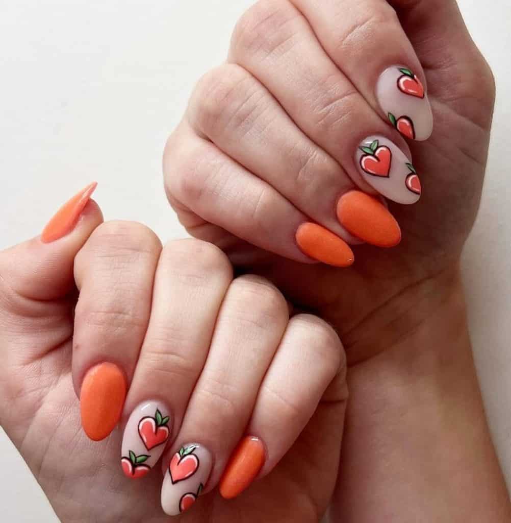 A closeup of a woman's hands with peach-orange nail polish that has peaches nail designs