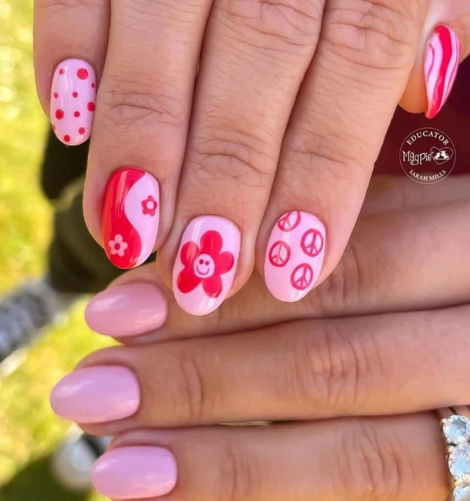 A closeup of a woman's hands with pink nail polish that has cute elements nail designs on select nails