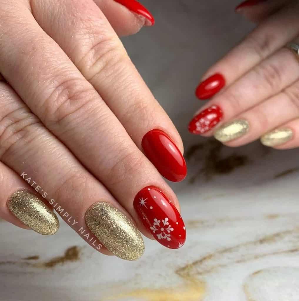 A closeup of a woman's hand with a combination of red and gold glitter manicure that has  white stars and snowflakes