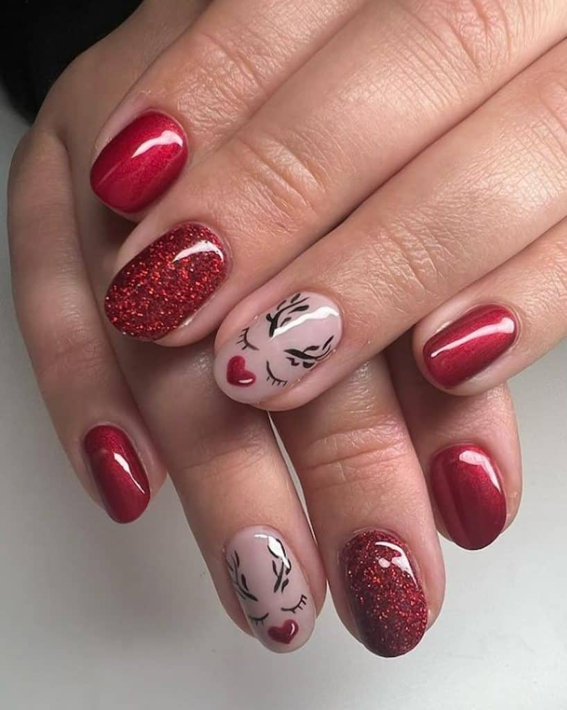 A closeup of a woman's hands with a combination of white and red nail polish that has reindeer nail art and glitter