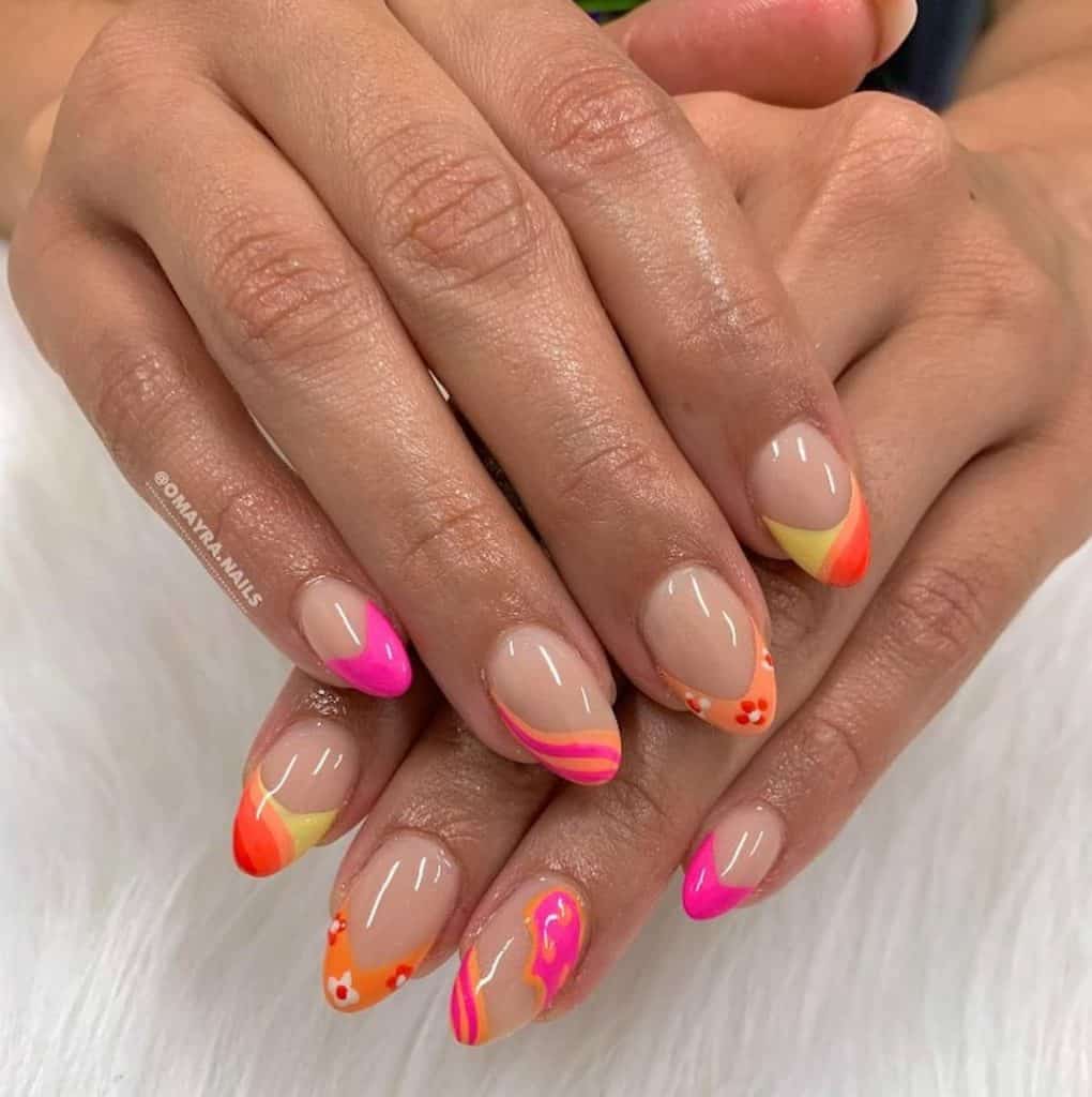 A closeup of a woman's hands with a nude nail polish and wavy-patterned tips in eye-catching cool colors on select nails
