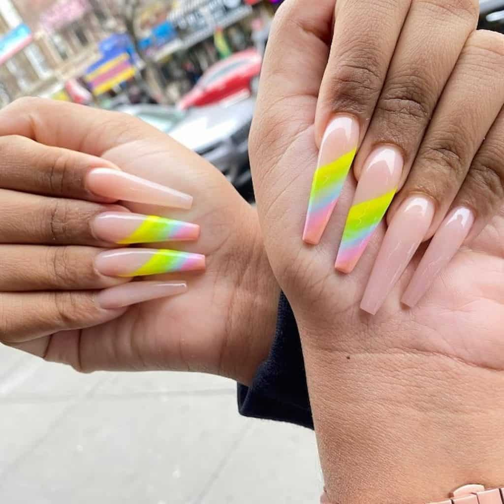 A woman's hands with sheer pink nail polish base that has rainbow rays nail designs