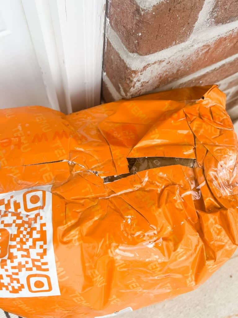 orange Temu package on a frontdoor step