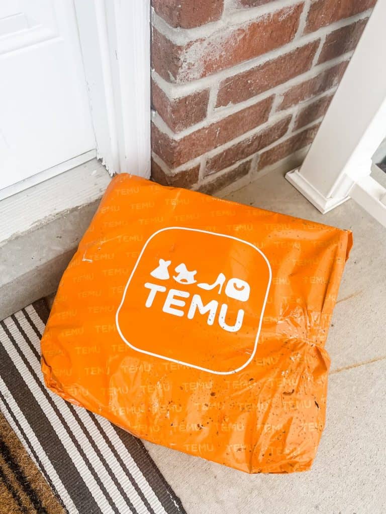 An orange temu package on a front porch.