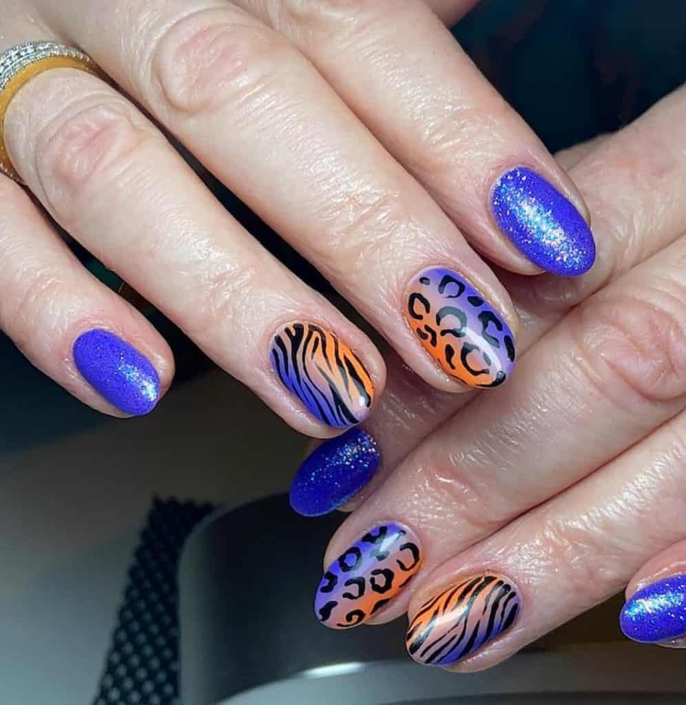A closeup of a woman's hands with a seamless orange-and-blue gradient that has leopard spots, white tiger stripes and glitter