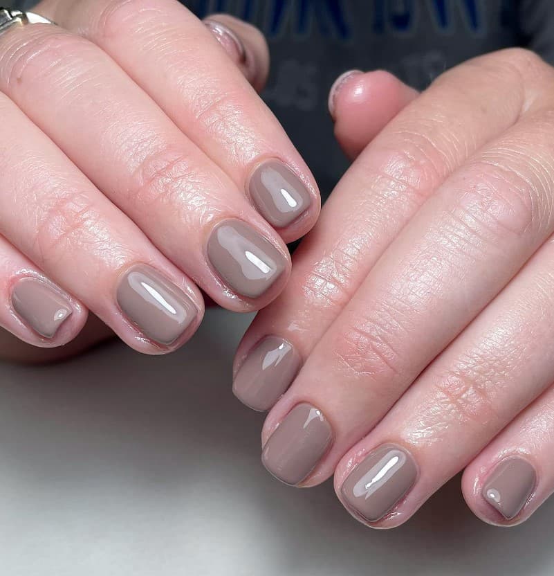 close up photo of woman's fingernails with taupe nail polish