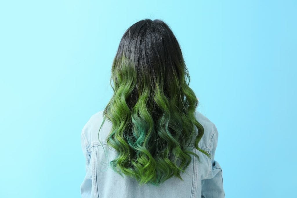 The back of a woman with long green hair.