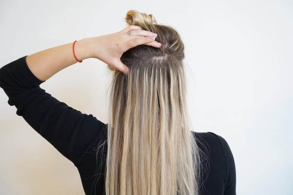 A photo of a woman's back and her long blonde hair with blonde hair extension