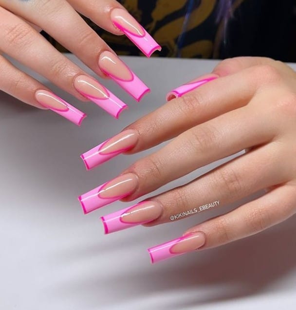 A closeup of a woman's hands with nude nail polish base that has French tips with a darker shade of pink