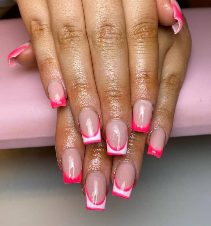 A woman's hands with nude nail polish base that has white tips framed with a sleek hot pink border nail designs