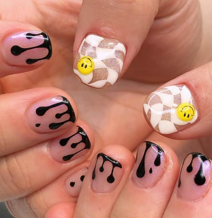 A closeup of a woman's fingernails with a glittery nude nail polish that has trippy, skewed checkerboards with smiley faces