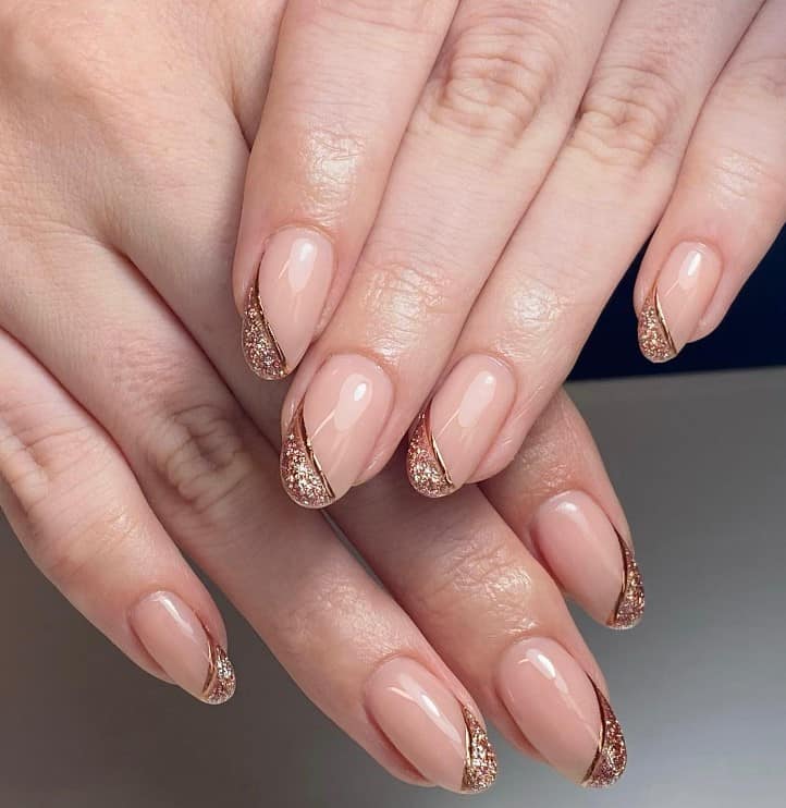 A closeup of a woman's fingernails with a glossy nude nail polish that has side French tips in rose gold lined with delicate rose gold borders