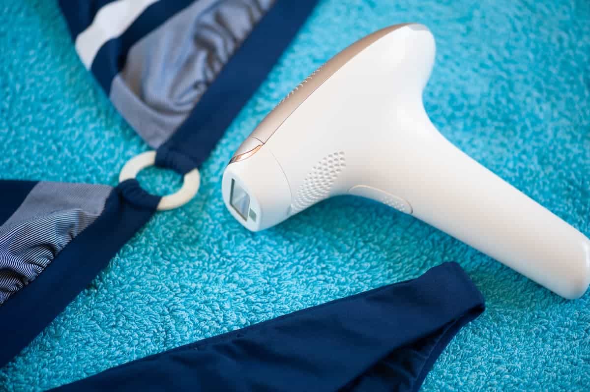 An IPL hair removal device and a blue towel on the background