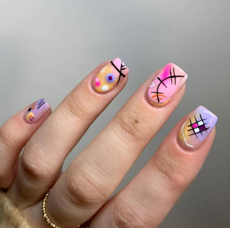 A closeup of a woman's fingernails with a multicolored nail polish base that has abstract patterns of lines