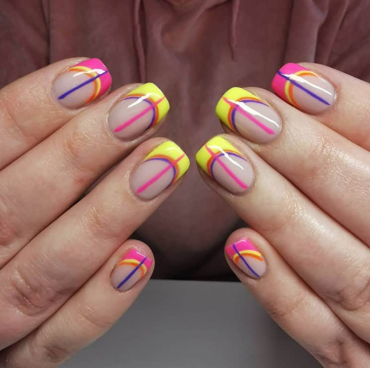 A closeup of a woman's with a nude nail polish that has sunny French tips and multicolored graphic line designs