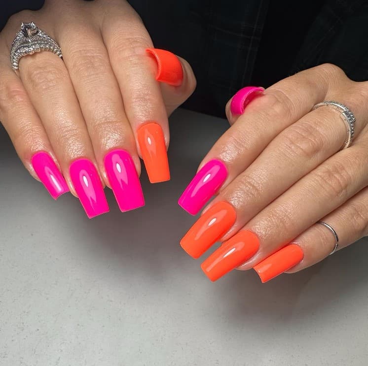 A woman's fingernails with a combination of nude and orange nail polish