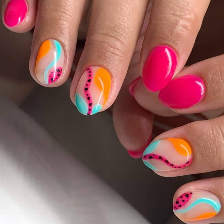 A closeup of a woman's fingernails with a combination of nude and pink nail polish that has pink and orange like turquoise or add black dots