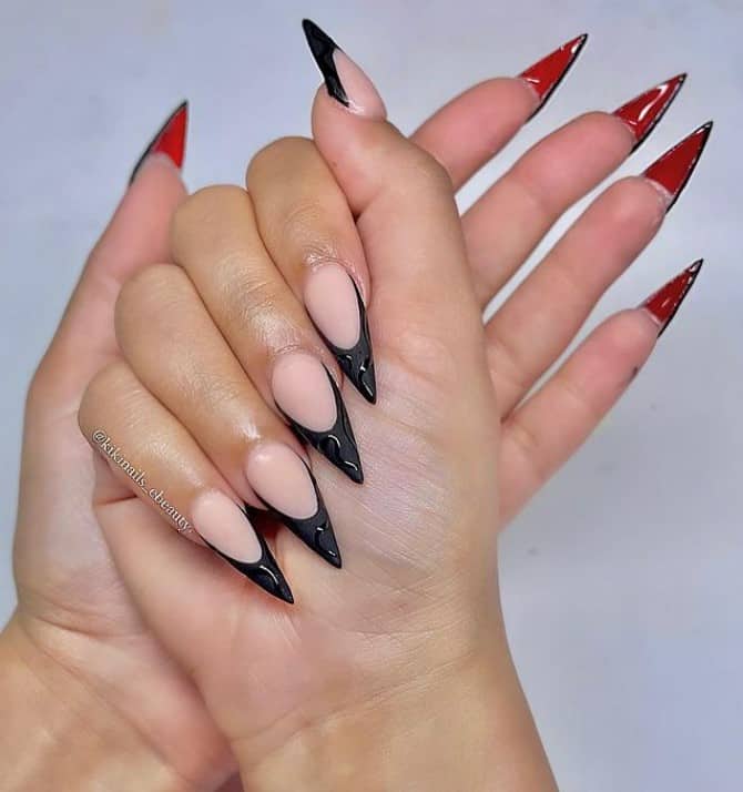A woman's fingernails with a nude nail polish base that has pointy tips in black