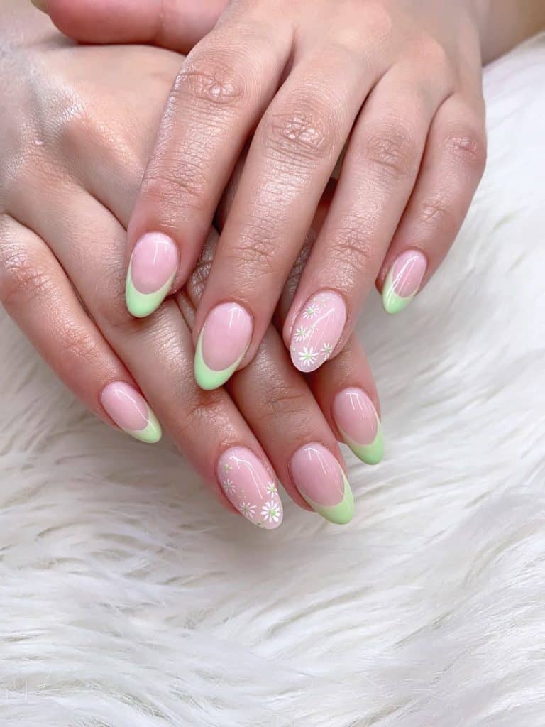A closeup of a woman's fingernails with shade of pink and soft green nail color that has minimalist flower accent on select nails 