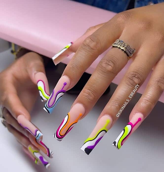 A woman's fingernails with a light-pink base that has abstract design of neon and black and white swirls at the tips
