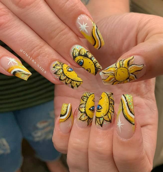 A closeup of a woman's fingernails with sun-themed nail art that has a mesmerizing combination of gold and white glitter