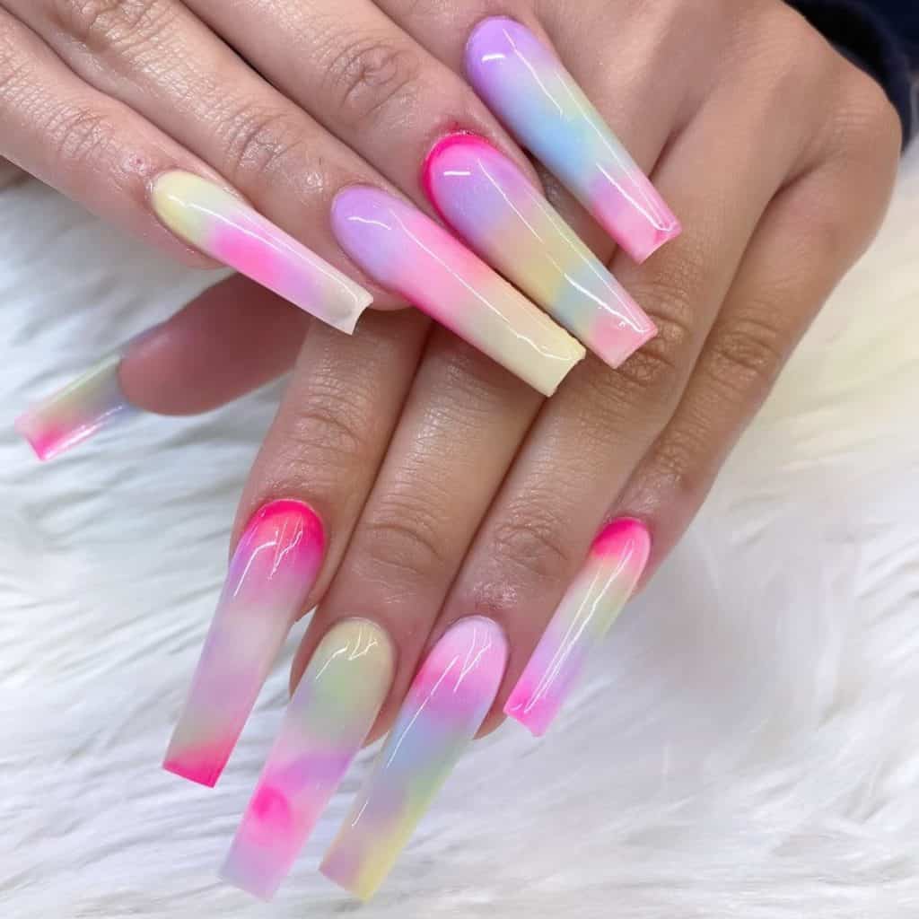 A woman's long coffin fingernails with multicolored pastel nail polish 