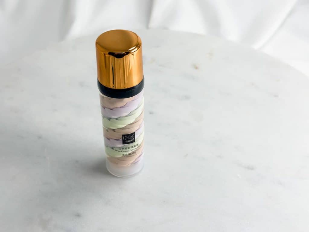A tricolor primer inside a beautiful packaging on top of a white marble table