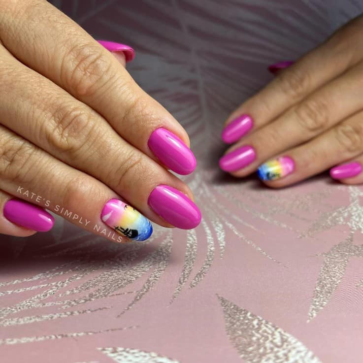 A woman's fingernails with a pink nail polish base that has tropical nail art in blue, yellow, and orange clor