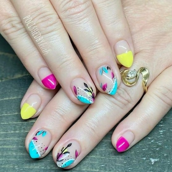 A closeup of a woman's fingernails with a nude nail polish that has abstract leaf art nail designs