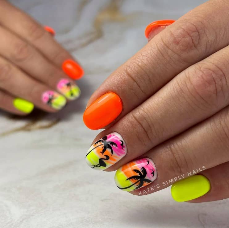 A closeup of a woman's fingernails with neon orange and yellow nail polish that has beach silhouettes nail designs