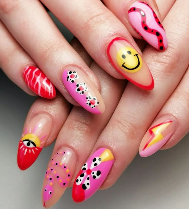 A closeup of a woman's long nails with nails outlined in red with smiley art, lightning zaps, flowers with Dalmatian prints, evil eye nail art, zebra prints, and pink-dotted snakes nail designs 