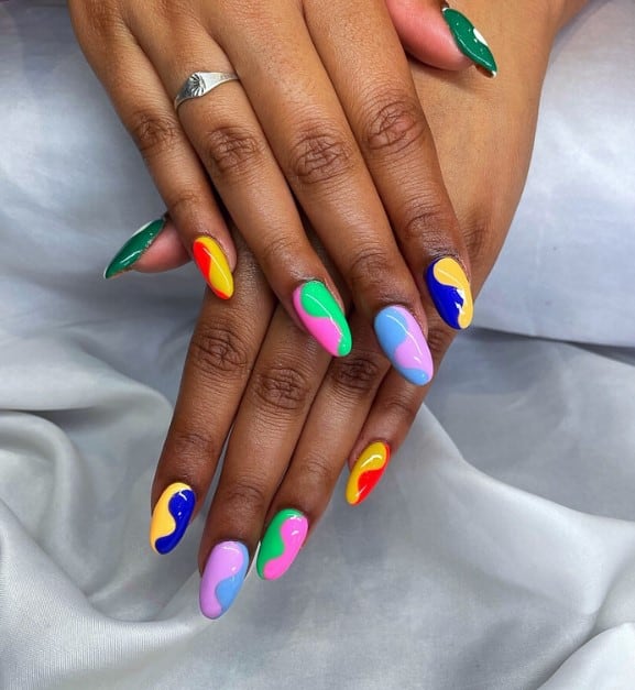 A woman's oval nails with bright two-tone colors nail polish that has a vertical swirl effect nail design