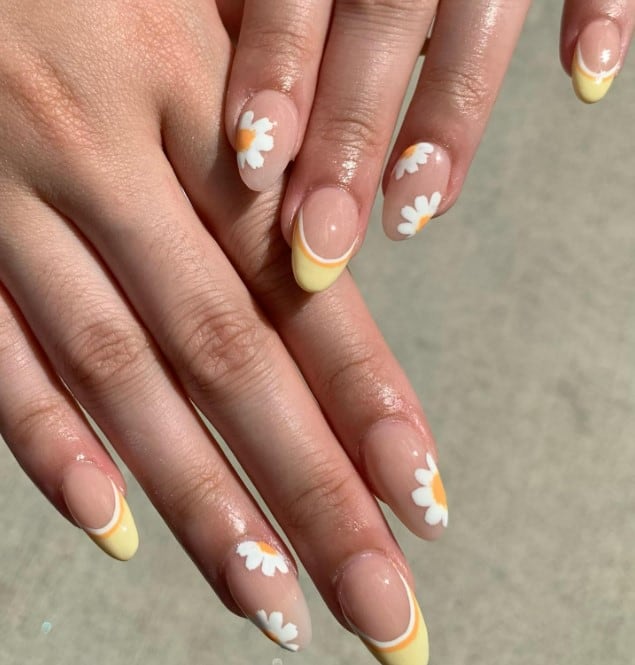 shiny almond daisy nails, where vibrant yellow French tips lined with orange and white exude a sunny and cheerful vibe