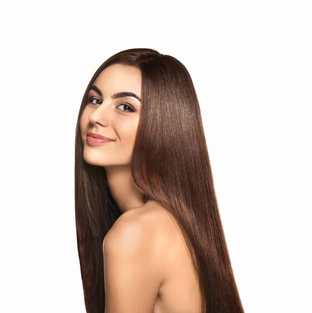 a beautiful young woman smiling at the camera with her shiny sleek long hair