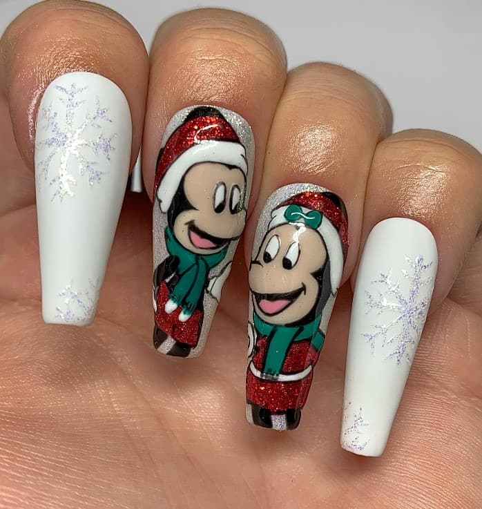 A closeup of a woman's fingernails with white nails and glitter nails that has glitter snowflakes, Minnie and Mickey nail art on select nails 