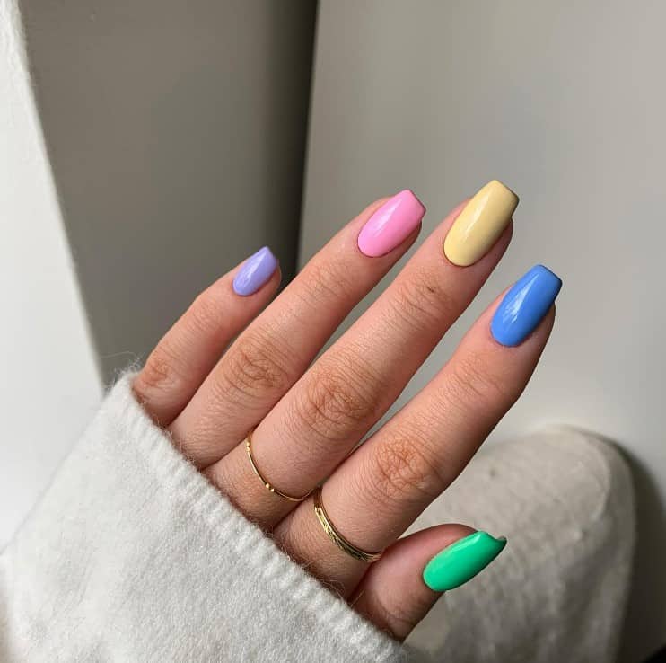 A woman's short nails with multicolored nail polish base 