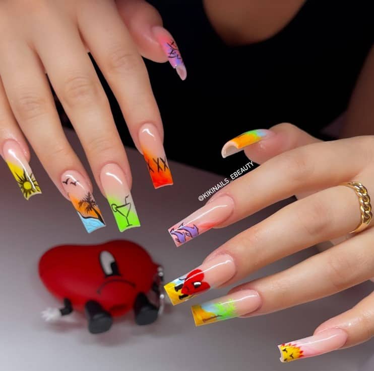A woman's nails with nude nail polish that has sun, palm trees, dolphins, and cocktails French tips 