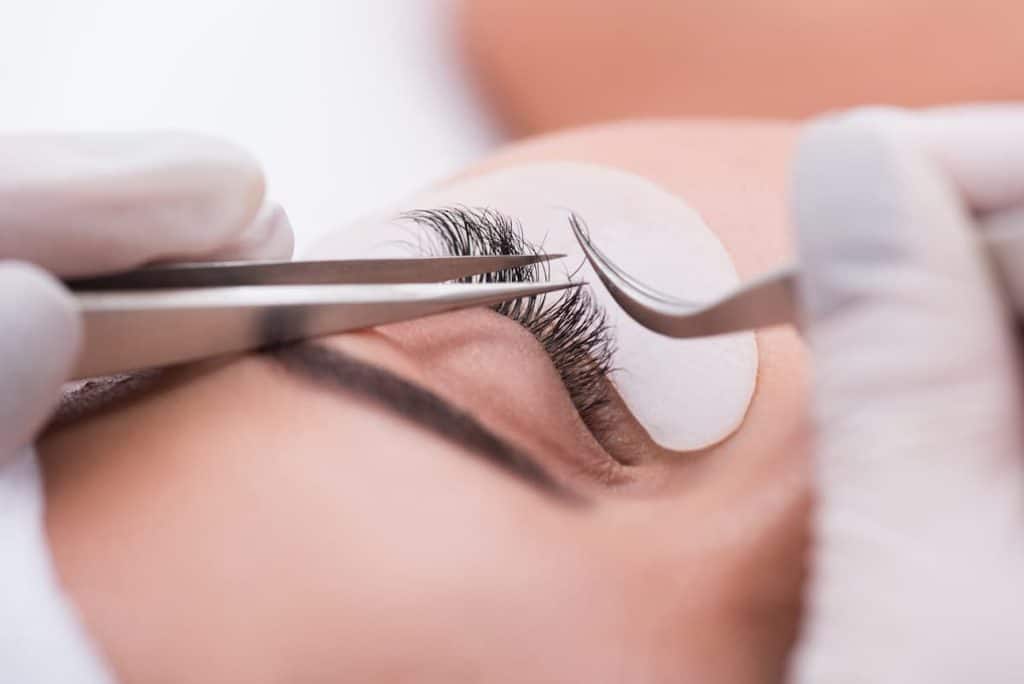 A woman getting eyelash extension styles