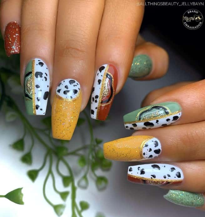 cow prints and geode-like patterns on some of the nails, which are separated with a gold glitter line